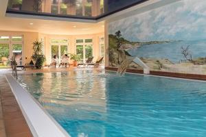 a large swimming pool in a house with a painting at Seepark Heidenholz, Plau am See in Plau am See