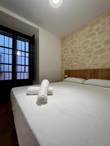 a bedroom with a large white bed with towels on it at Apartamentos Rey in Córdoba