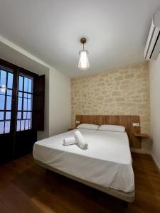 1 dormitorio con 1 cama y 2 toallas blancas en Apartamentos Rey, en Córdoba