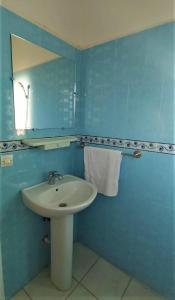 uma casa de banho azul com um lavatório e um espelho em Hôtel Titrit em Tafraout