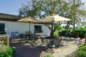 a patio with tables and chairs and umbrellas at Covered Wagon Motel Lusk WY in Lusk