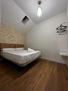 a bedroom with a bed and a light on the wall at Apartamentos Rey in Córdoba