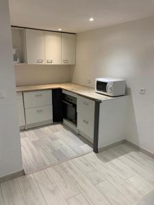 a kitchen with a counter with a microwave on it at Appartement 1er Etage 42m2 hyper centre ville / parking gratuit in Riom