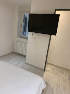 Pokój z łóżkiem i telewizorem z płaskim ekranem w obiekcie Appartement 1er Etage 42m2 hyper centre ville / parking gratuit w mieście Riom