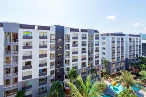 an apartment building with a pool and palm trees at First Hua Hin - Ji Ya in Hua Hin