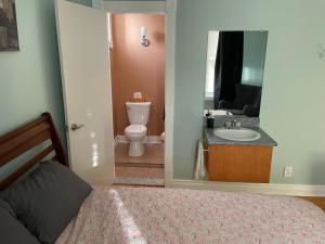 トロワ・リヴィエールにあるAuberge du Mondeのベッドルーム1室(ベッド1台付)、バスルーム(シンク付)