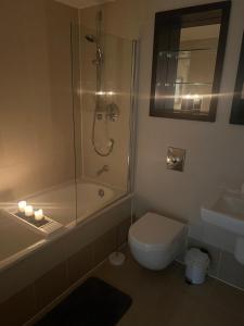a bathroom with a shower and a toilet and a sink at Sugarhill Leeds docks in Leeds