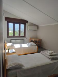 two beds in a room with a window at Lake and Mountain Suits in Verceia