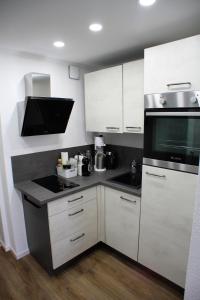 a kitchen with white cabinets and a black counter top at Gemütliches Studio mit Ausblick, Pool und WiFi in Baiersbronn