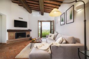 uma sala de estar com um sofá e uma lareira em Casa Ora d'Oro - PANORAMIC VIEWS / POOL / PRIVATE GARDEN em Trequanda