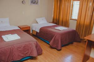 Habitación hospitalaria con 2 camas y ventana en Hostal Premier Arequipa, en Arequipa