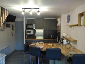 a kitchen with a wooden table and blue chairs at Chezmaryline in Vielle-Aure