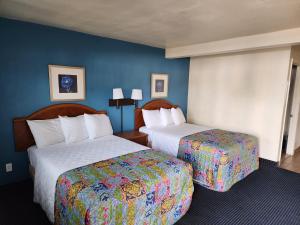 een hotelkamer met 2 bedden en blauwe muren bij Chandler Inn in Chandler