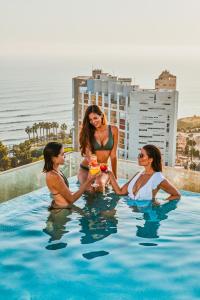 un grupo de tres mujeres sentadas en una piscina en Iberostar Selection Miraflores, en Lima