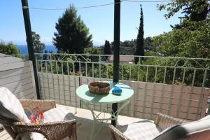 a patio with a table and chairs on a balcony at Pelagos in Stafylos