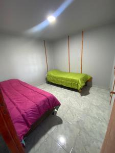 Habitación con 2 camas y manta verde. en CABAÑAS MZA RANCH en Las Compuertas
