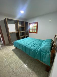1 dormitorio con 1 cama con edredón azul en CABAÑAS MZA RANCH en Las Compuertas