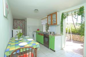 una cocina con electrodomésticos verdes y una mesa con sillas. en Villa Hope 1, en Vela Luka