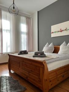 een slaapkamer met een groot houten bed met 2 kussens erop bij AKK5 Großes Apartment mit Terrasse Nähe Hbf/Uni in Maagdenburg