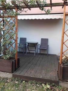 een houten terras met 2 stoelen en een tafel bij AKK5 Großes Apartment mit Terrasse Nähe Hbf/Uni in Maagdenburg