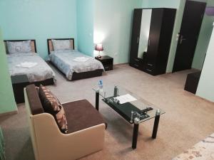 Habitación con 2 camas, sofá y mesa. en Complex MONACO HOTEL & CASINO en Svilengrad