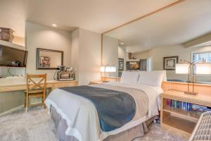 a bedroom with a large bed and a desk and a chair at River Ridge 332AB in Bend