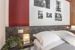 sypialnia z łóżkiem i obrazami na ścianie w obiekcie MilanRentals - Altea Apartment w Mediolanie +6 zdjęć