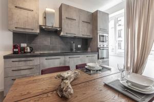 kuchnia z drewnianym stołem z krzesłami i jadalnią w obiekcie MilanRentals - Altea Apartment w Mediolanie