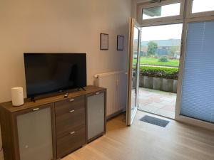 un soggiorno con TV a schermo piatto su un comò di Apartment mit vier Einzelboxspringbetten - Netflix a Goch