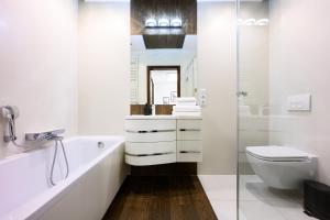 a white bathroom with a toilet and a sink at Native Apartments Masarska 8/5 in Kraków +35 photos