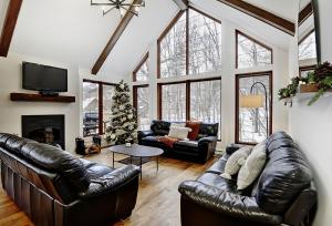 uma sala de estar com mobiliário de couro e uma árvore de Natal em Chalets Alpins- 27 Chemin des Skieurs em Stoneham
