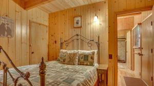 a bedroom with a bed in a room with wooden walls at Moosewood Cabin - Meredith Lodging in Government Camp
