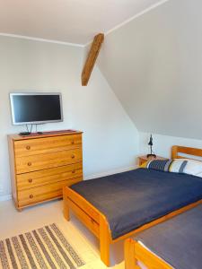 a bedroom with two beds and a tv on a dresser at Morski Zakątek Kołobrzeg - Dom z ogrodem na wyłączność in Kołobrzeg
