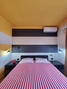 ein rot-weißes gestreiftes Bett in einem Zimmer in der Unterkunft Helga’s Sunset apartment in Tirana
