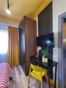 ein Schlafzimmer mit einem Schreibtisch und einem gelben Stuhl in der Unterkunft Helga’s Sunset apartment in Tirana