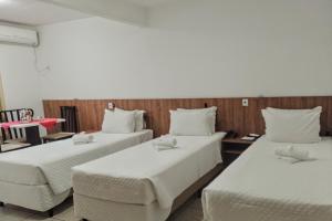 um quarto com duas camas e uma cadeira em Flat Sol em Balneário Camboriú
