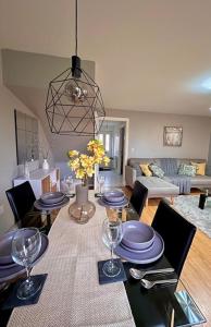 uma sala de jantar com uma mesa com pratos e copos de vinho em Modern 3BR House For Contractors em Stockingford