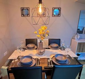 una mesa de comedor con platos y vasos. en Modern 3BR House For Contractors, en Stockingford