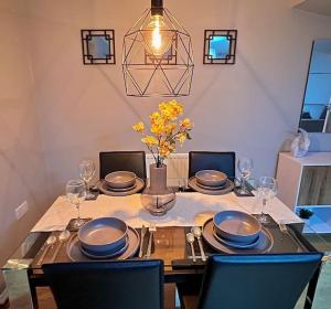 a dining room table with plates and glasses on it at Modern 3BR House For Contractors in Stockingford +12 photos