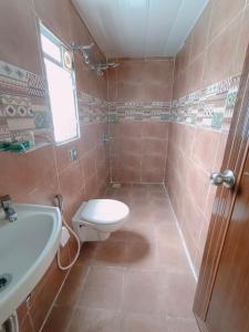 a bathroom with a toilet and a sink at Tamboo Resort Vajreshwari in Thane