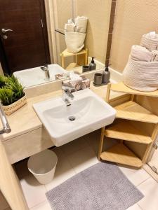 ein Badezimmer mit einem weißen Waschbecken und einem Spiegel in der Unterkunft Super Elegant studio apartment-Sparkle tower By SWEET HOMES in Dubai
