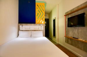 um quarto com uma cama grande e uma televisão na parede em ibis budget Tambore em Barueri