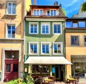 een gebouw met tafels en stoelen ervoor bij Seesterne City in Konstanz