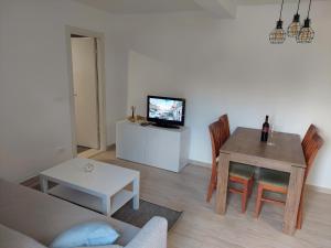 a living room with a couch and a table with a television at Apartment by AntunovicWinery in Trpanj