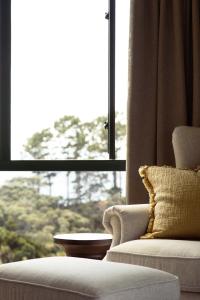 a living room with a chair and a window at Vineyard Apartment in Tutukaka