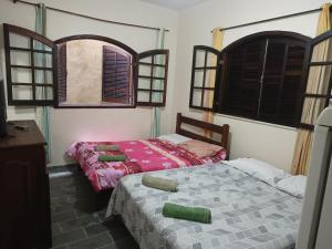 dwa łóżka w pokoju z dwoma oknami w obiekcie POUSADA VISTA CHINESA w mieście Rio de Janeiro