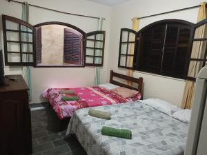 two beds in a room with two windows at POUSADA VISTA CHINESA in Rio de Janeiro