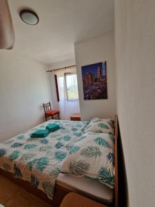 ein Schlafzimmer mit einem Bett mit einer Bettdecke darauf in der Unterkunft Apartment Opaćac Veli Iž in Veli Iž