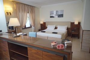 a hotel room with a bed and a desk at Suites & Residence Hotel in Pozzuoli