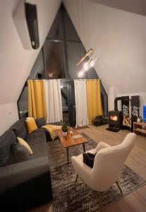 Klek 77 Luxury Chalets near Jahorina : غرفة معيشة مع أريكة وطاولة
